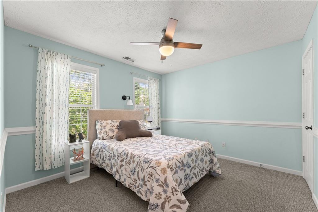 4055 Ivy Run Circle Duluth, GA 30096 - Photo 26 of 55 a bedroom with a bed and a chandelier