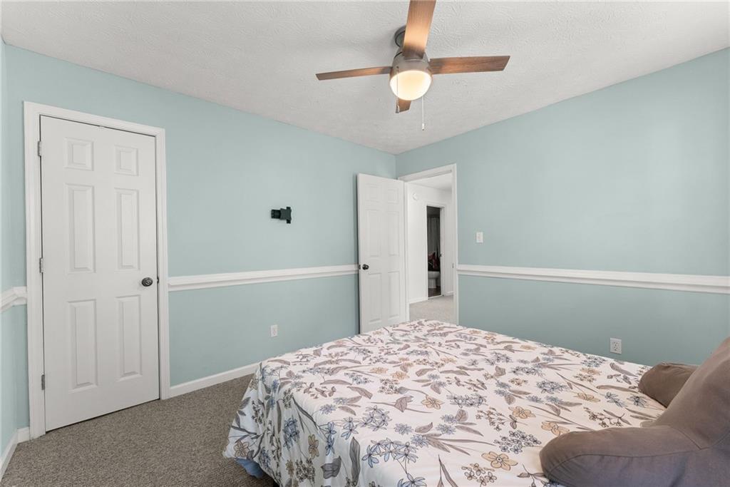 4055 Ivy Run Circle Duluth, GA 30096 - Photo 27 of 55 a bedroom with a bed and a chandelier