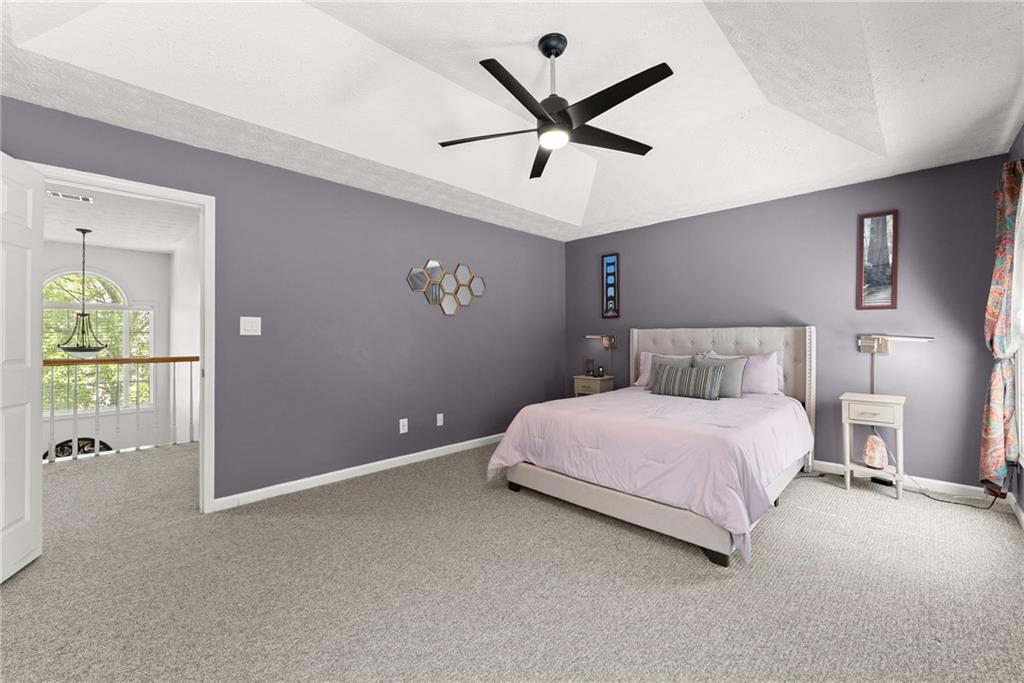 4055 Ivy Run Circle Duluth, GA 30096 - Photo 30 of 55 a bedroom with a large bed and a chandelier