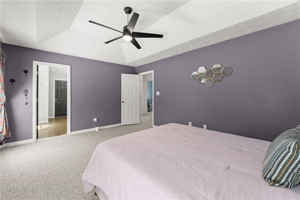 4055 Ivy Run Circle Duluth, GA 30096 - Photo 31 of 55 a bedroom with a large bed and a chandelier