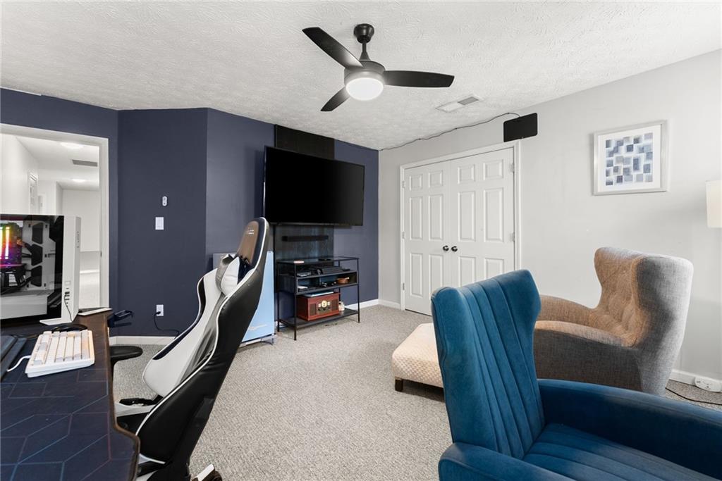 4055 Ivy Run Circle Duluth, GA 30096 - Photo 37 of 55 a living room with furniture a flat screen tv and a ceiling fan