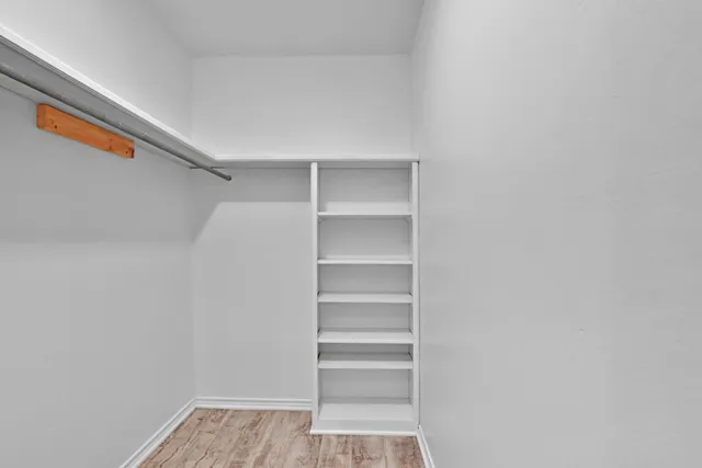a view of walk in closet with empty racks
