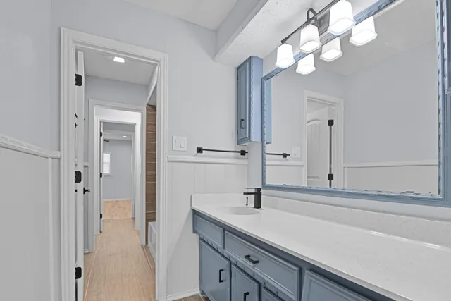 a bathroom with a sink a light fixture and a mirror