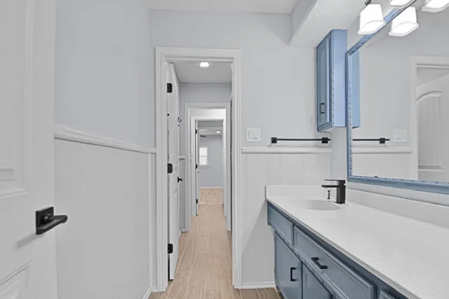 a bathroom with a sink vanity granite and shower