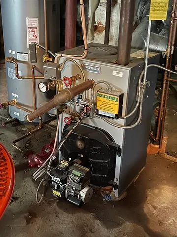 a room with water heater and a wooden floor