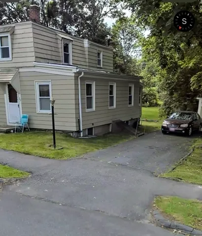 a view of a house with a backyard and trees