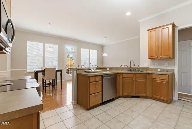 a large kitchen with granite countertop a stove a sink a dining table and chairs