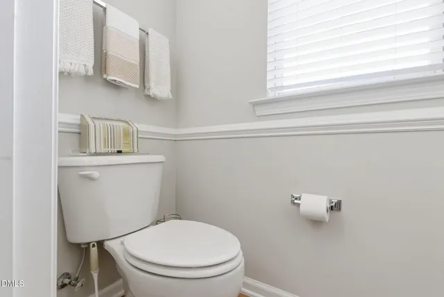 a bathroom with a toilet a sink and a window