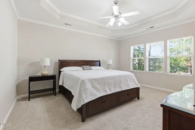 a bed sitting in a spacious bedroom next to a window