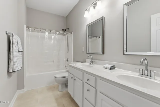 a bathroom with a double vanity sink toilet mirror and shower