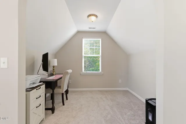 a view of a workspace with furniture and window