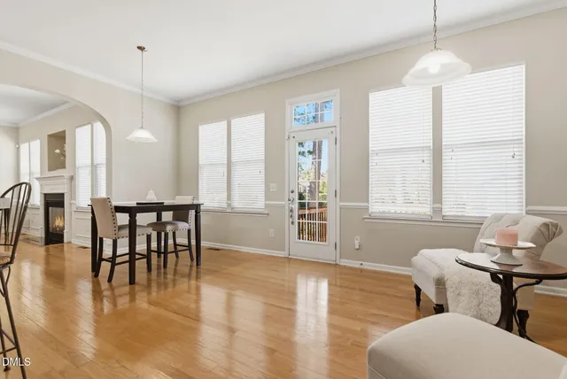 a view of a dining room and livingroom with furniture wooden floor a chandelier
