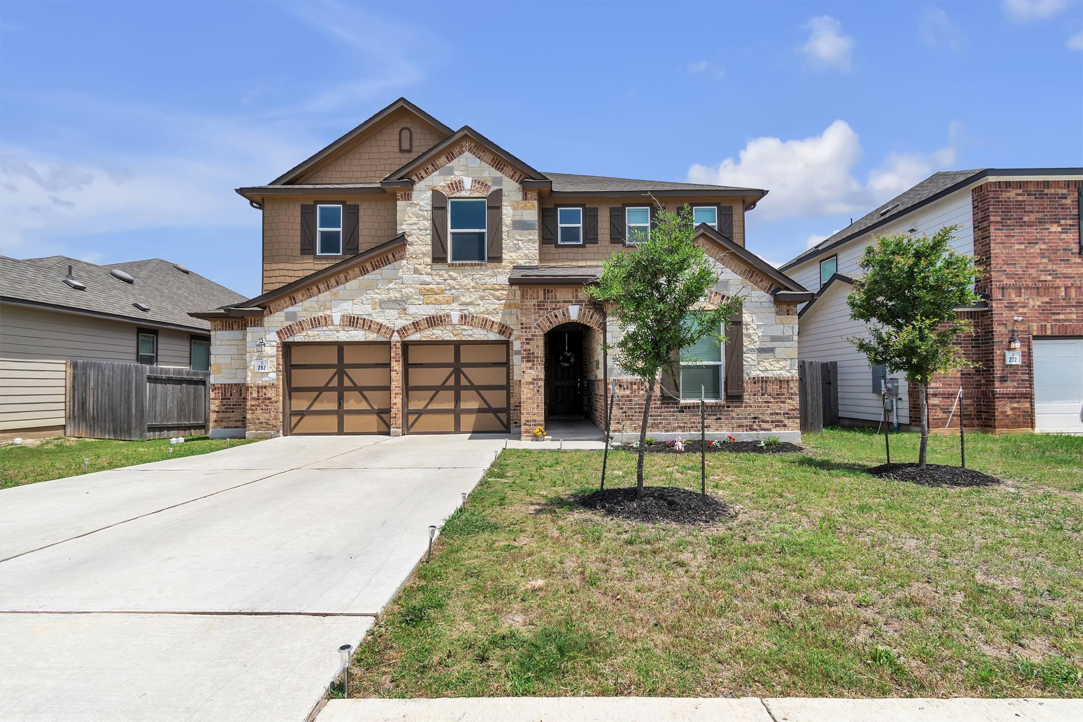 Craftsman-style house with driveway, a garage, and stone siding