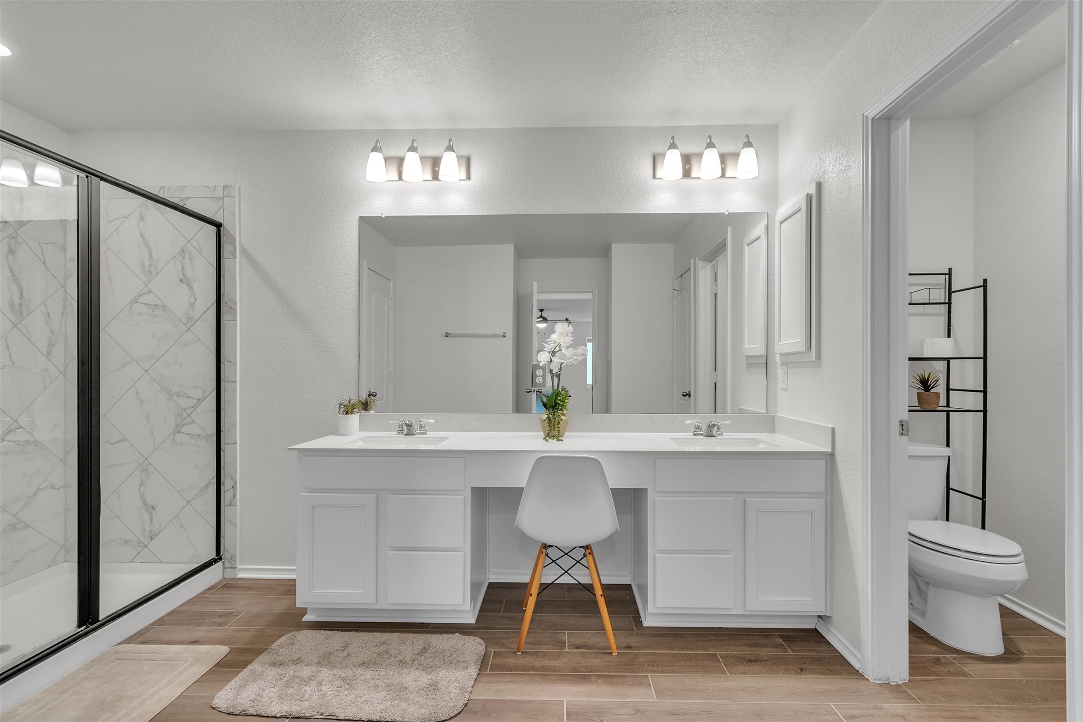 282 Crimson Lane Kyle, TX 78640 - Photo 14 of 18 Full bathroom featuring wood tiled floors, double vanity, a marble finish shower, and a textured ceiling