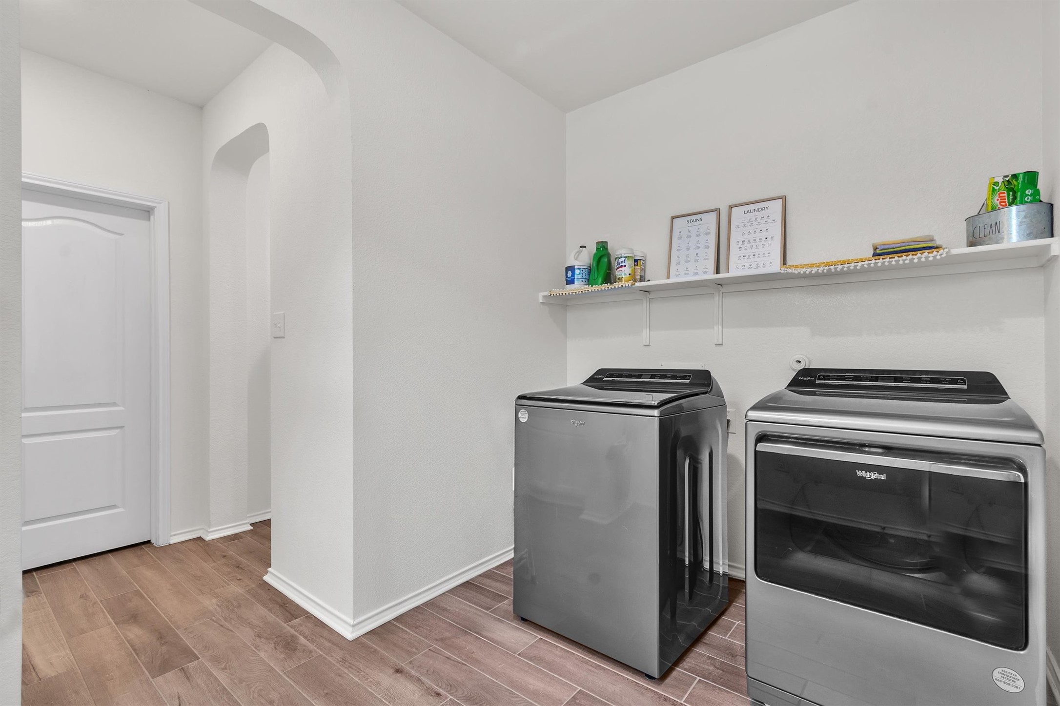 282 Crimson Lane Kyle, TX 78640 - Photo 15 of 18 Washroom featuring wood tiled floors, washing machine and clothes dryer, and arched walkways