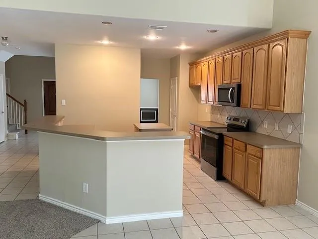 a kitchen with stainless steel appliances granite countertop a stove a sink and a microwave