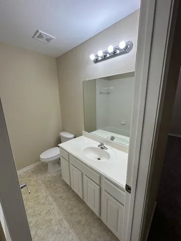 wooden floor in an empty room with a chandelier fan