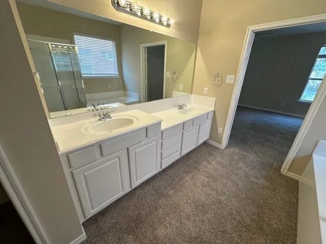 a spacious bathroom with a double vanity sink and a mirror