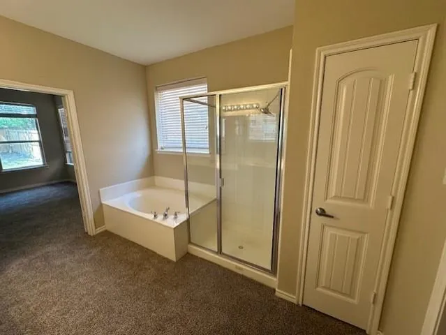 a spacious bathroom with a tub shower and a sink