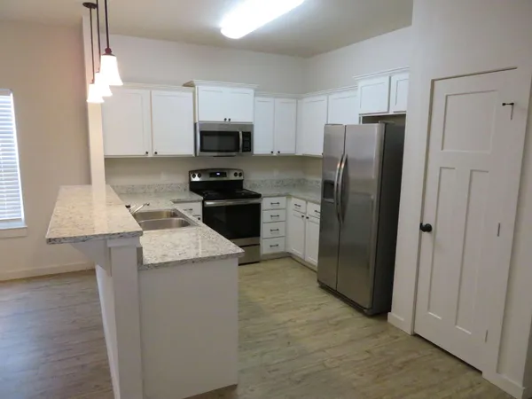 a kitchen with stainless steel appliances granite countertop a refrigerator stove microwave and sink