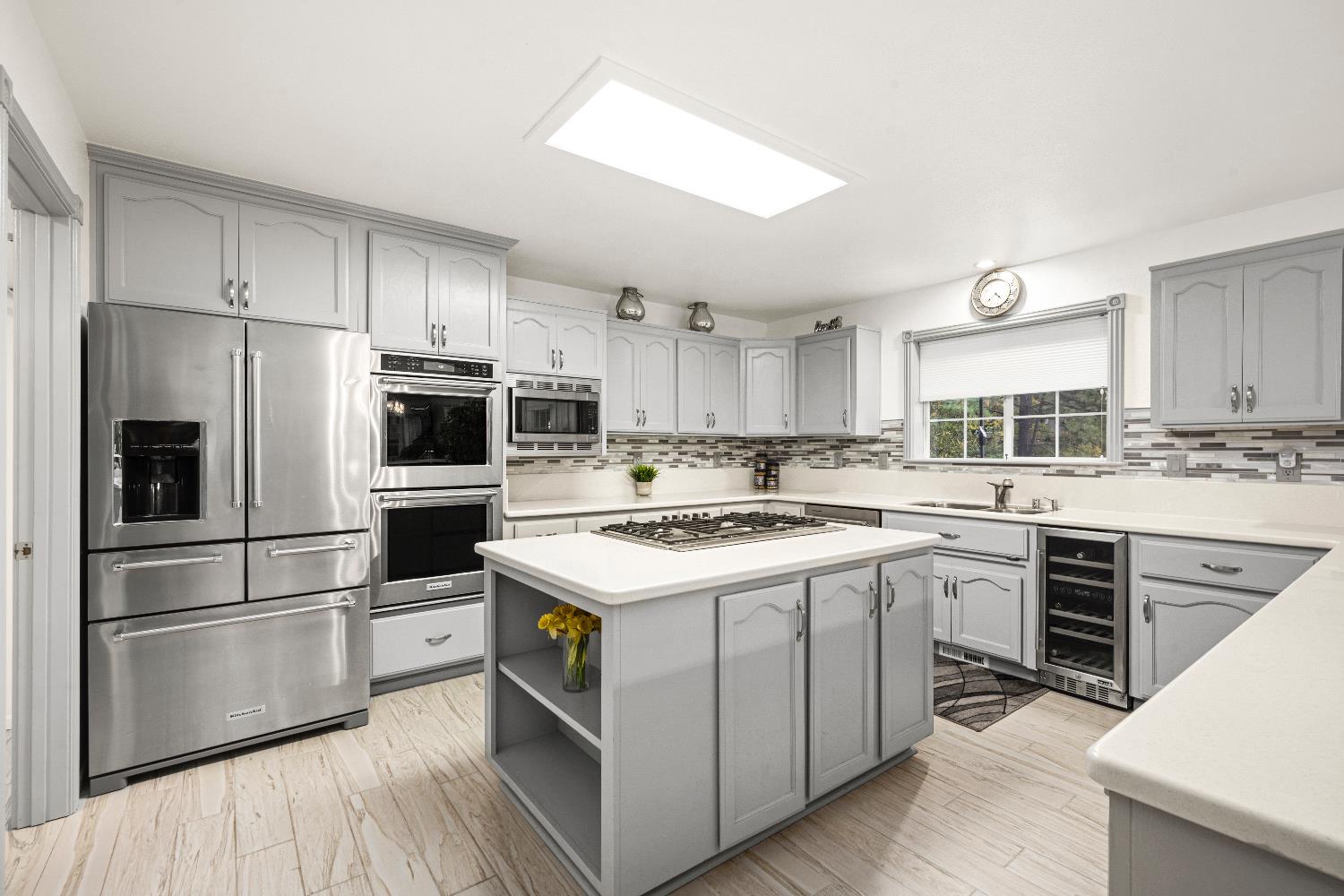 1049 Kimi Way Placerville, CA 95667 - Photo 13 of 66 a kitchen with a stove a sink dishwasher a refrigerator and a microwave oven with wooden floor