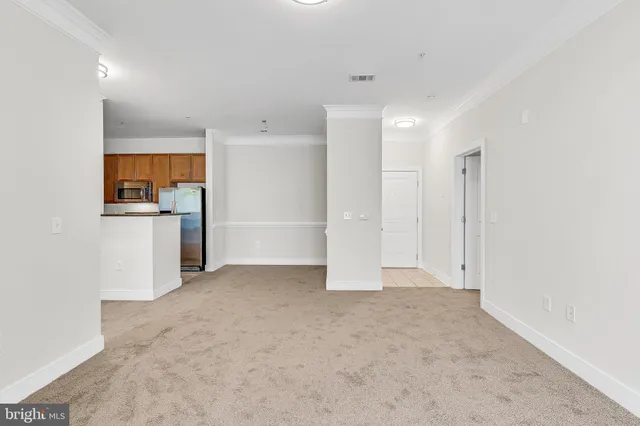 a view of a kitchen with a refrigerator a stove top oven and cabinets