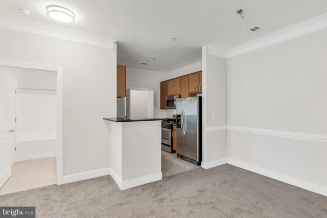 a view of a kitchen with refrigerator and a sink