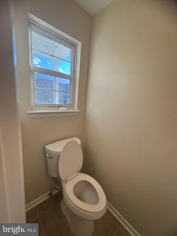 a white toilet sitting next to a window
