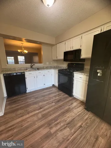 a kitchen with stainless steel appliances granite countertop a sink refrigerator and microwave