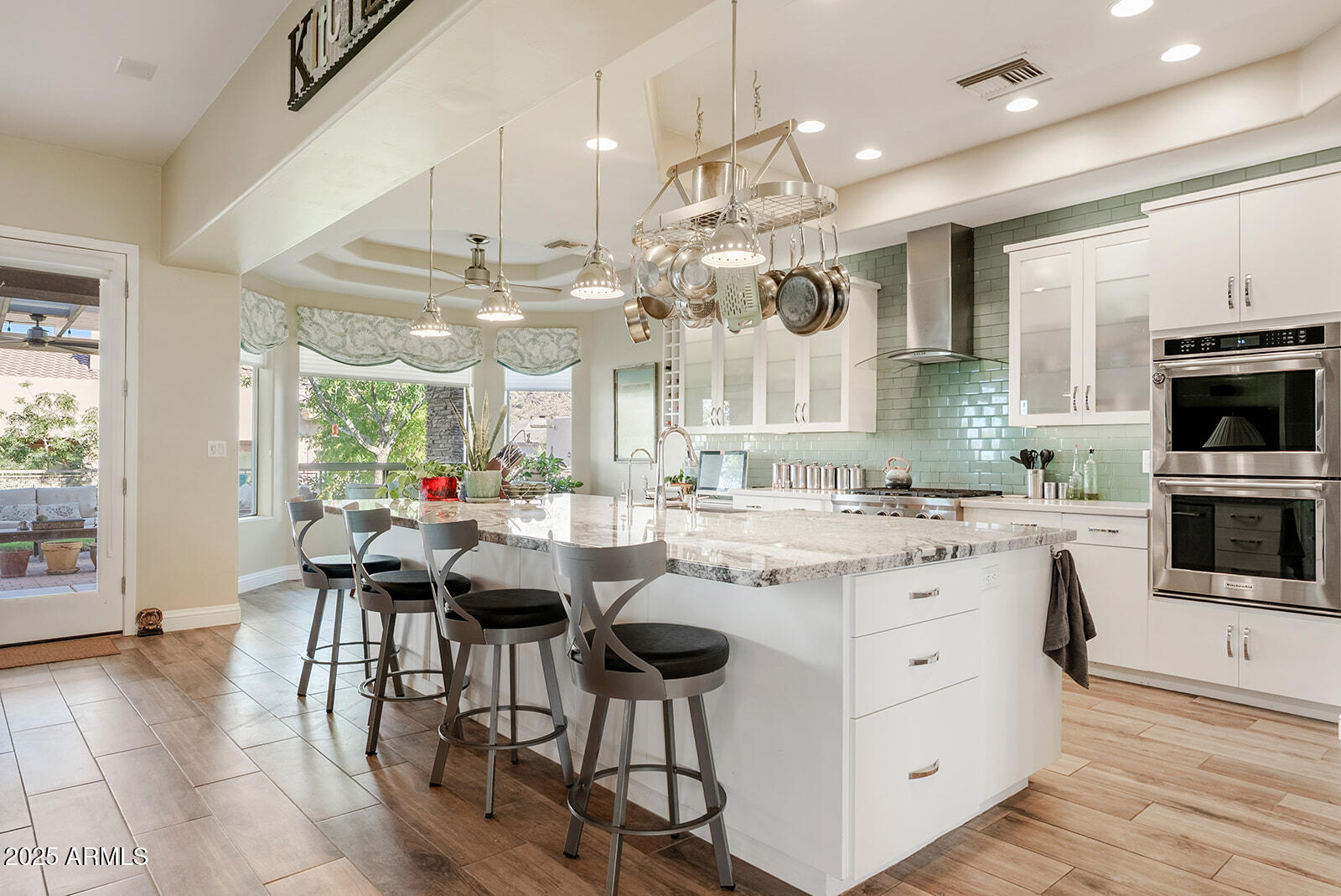 8705 South 24th Place Phoenix, AZ 85042 - Photo 14 of 43 a kitchen with kitchen island granite countertop a table chairs sink and cabinets