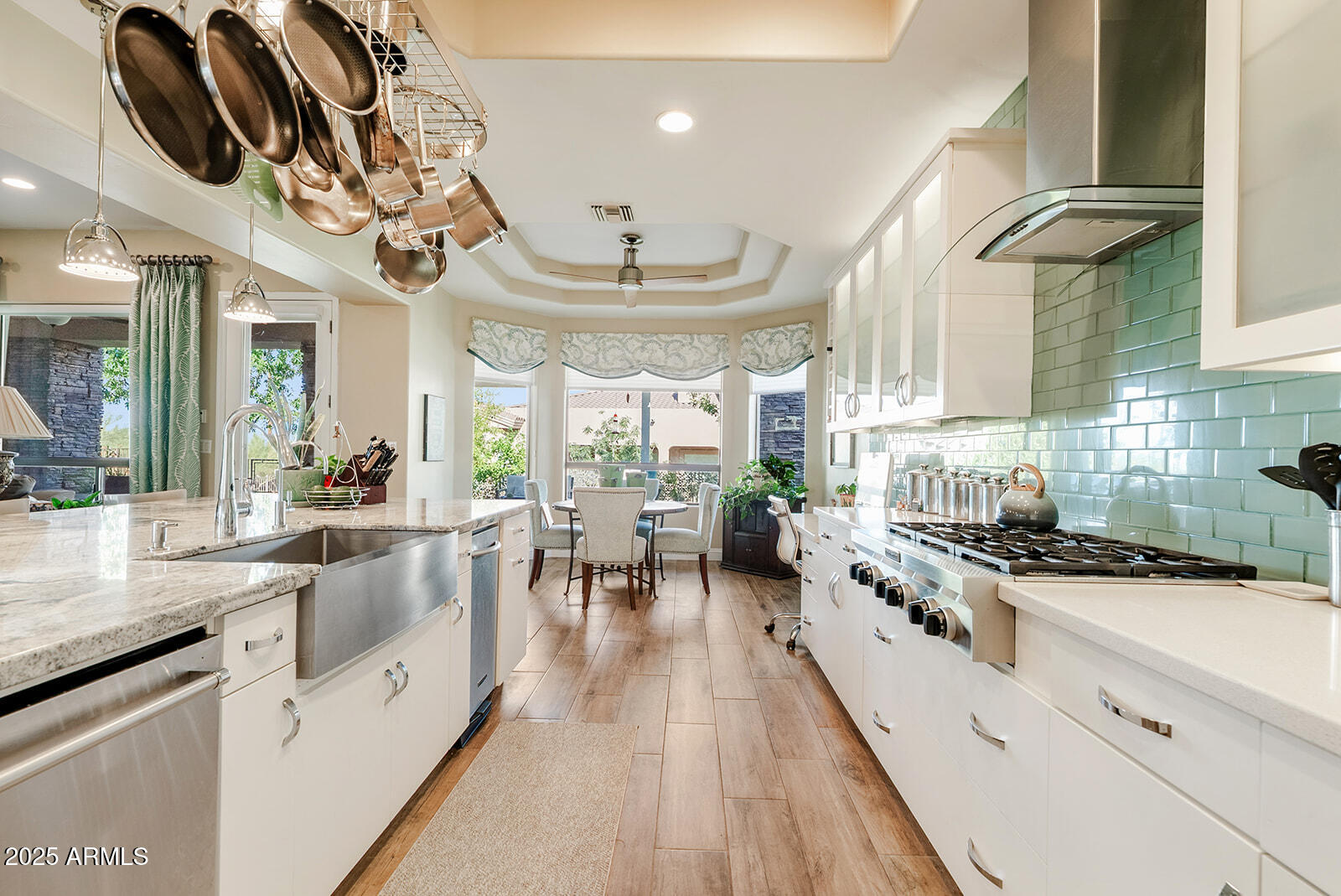 8705 South 24th Place Phoenix, AZ 85042 - Photo 15 of 43 a kitchen with stainless steel appliances a stove a sink a dining table and chairs with wooden floor