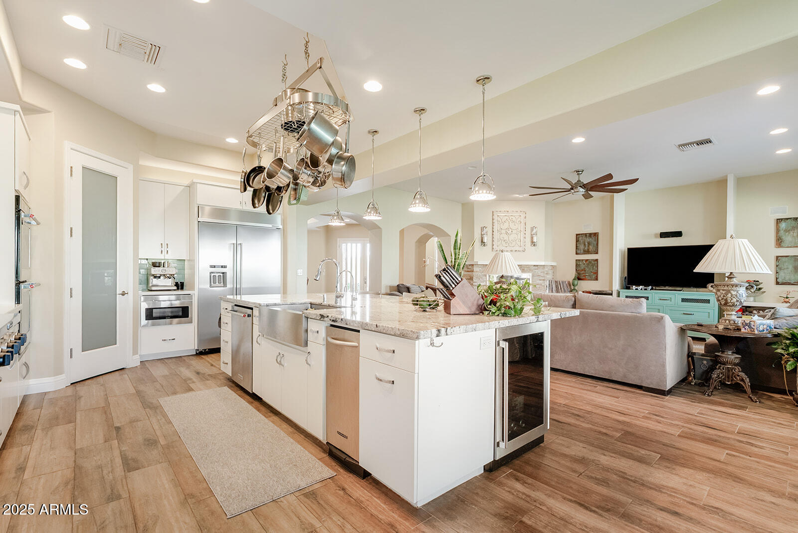 8705 South 24th Place Phoenix, AZ 85042 - Photo 17 of 43 a large white kitchen with stainless steel appliances kitchen island granite countertop a large kitchen island and a couch