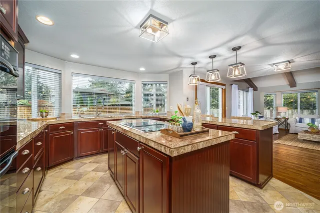 a kitchen with granite countertop sink stove and cabinets