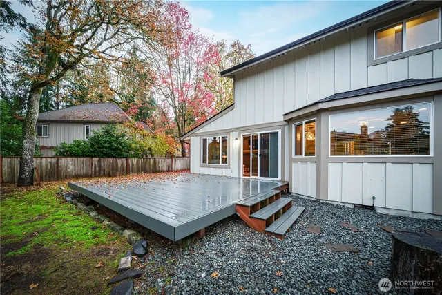 a view of wooden house with a yard and wooden fence