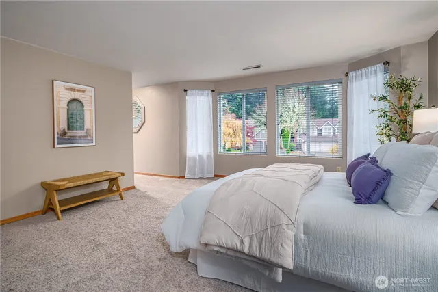 a bedroom with a bed next to a large window