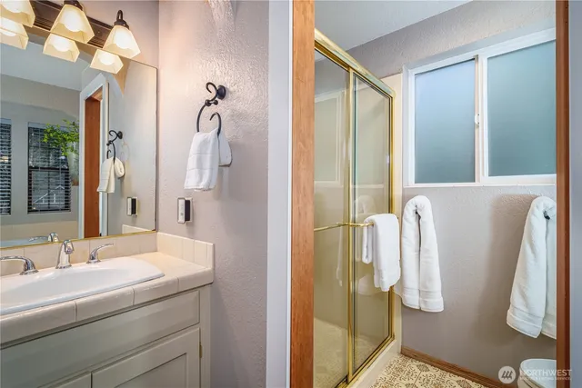 a bathroom with a double vanity sink a mirror and shower