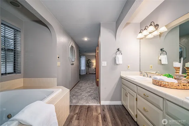 a spacious bathroom with a granite countertop sink and a mirror