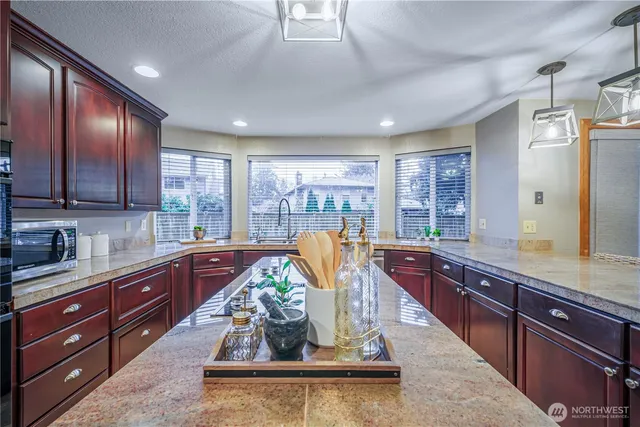 a kitchen with stainless steel appliances granite countertop sink stove and cabinets