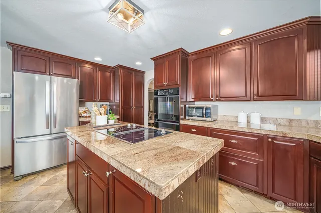 a kitchen with stainless steel appliances granite countertop a sink stove and refrigerator
