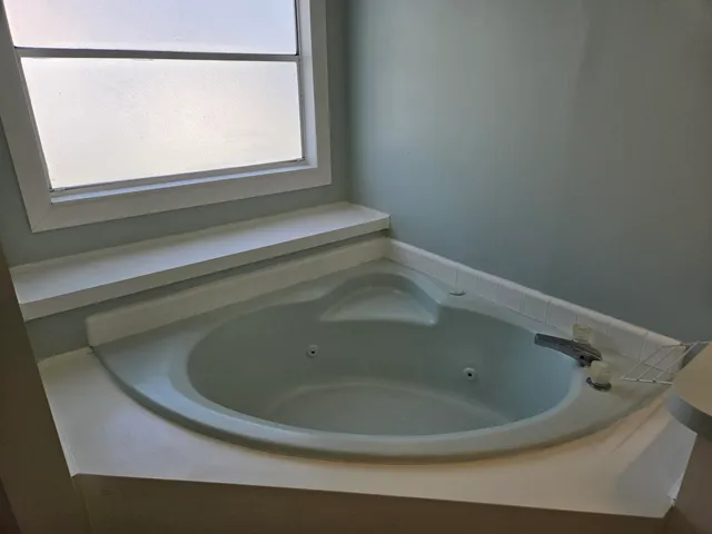 a bathroom with a tub sink and mirror