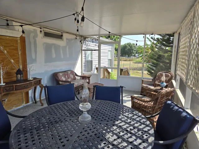 a dining room with furniture and a floor to ceiling window