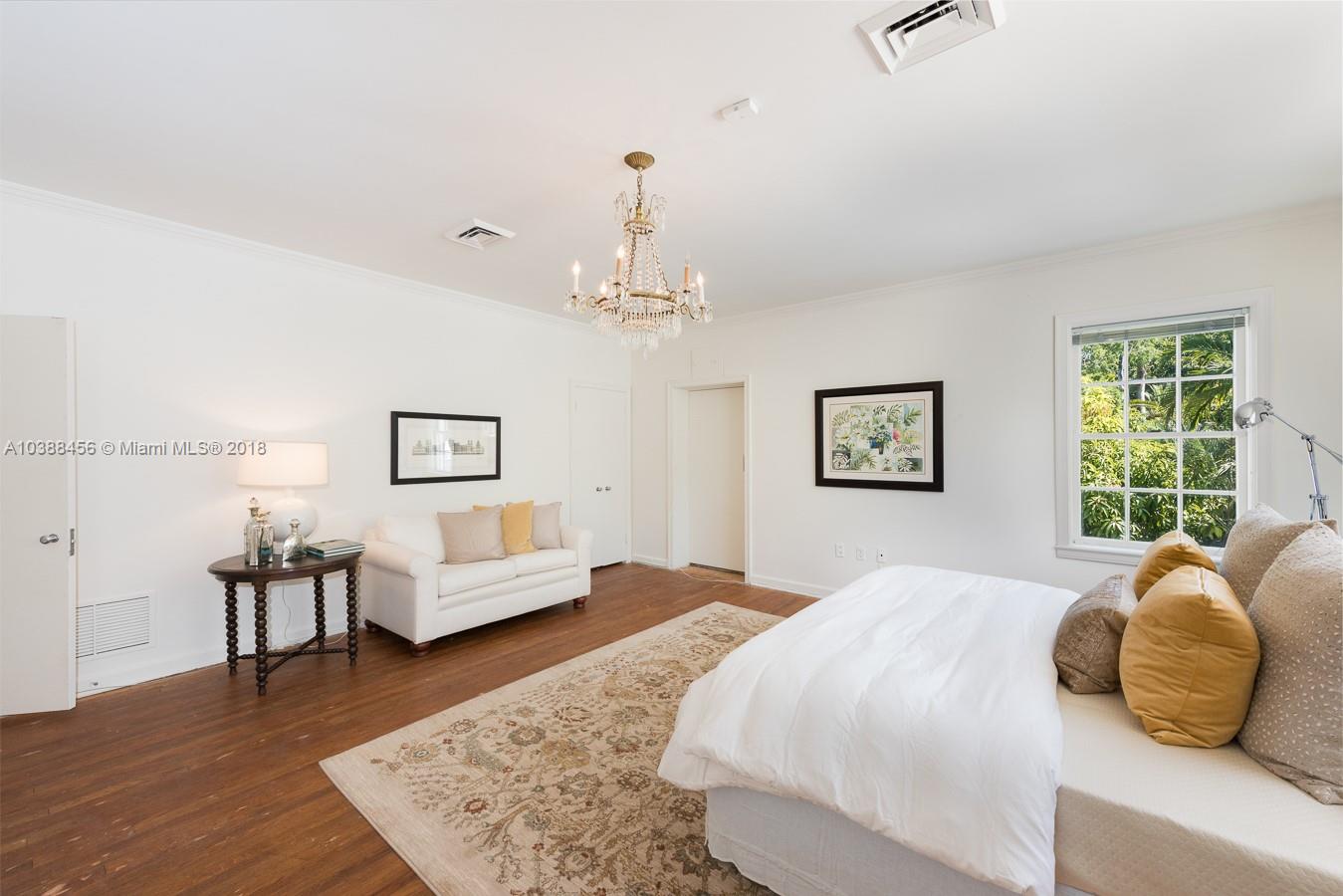 6645 Pine Tree Lane Miami Beach, FL 33141 - Photo 17 of 21 a spacious bedroom with a bed and wooden floor
