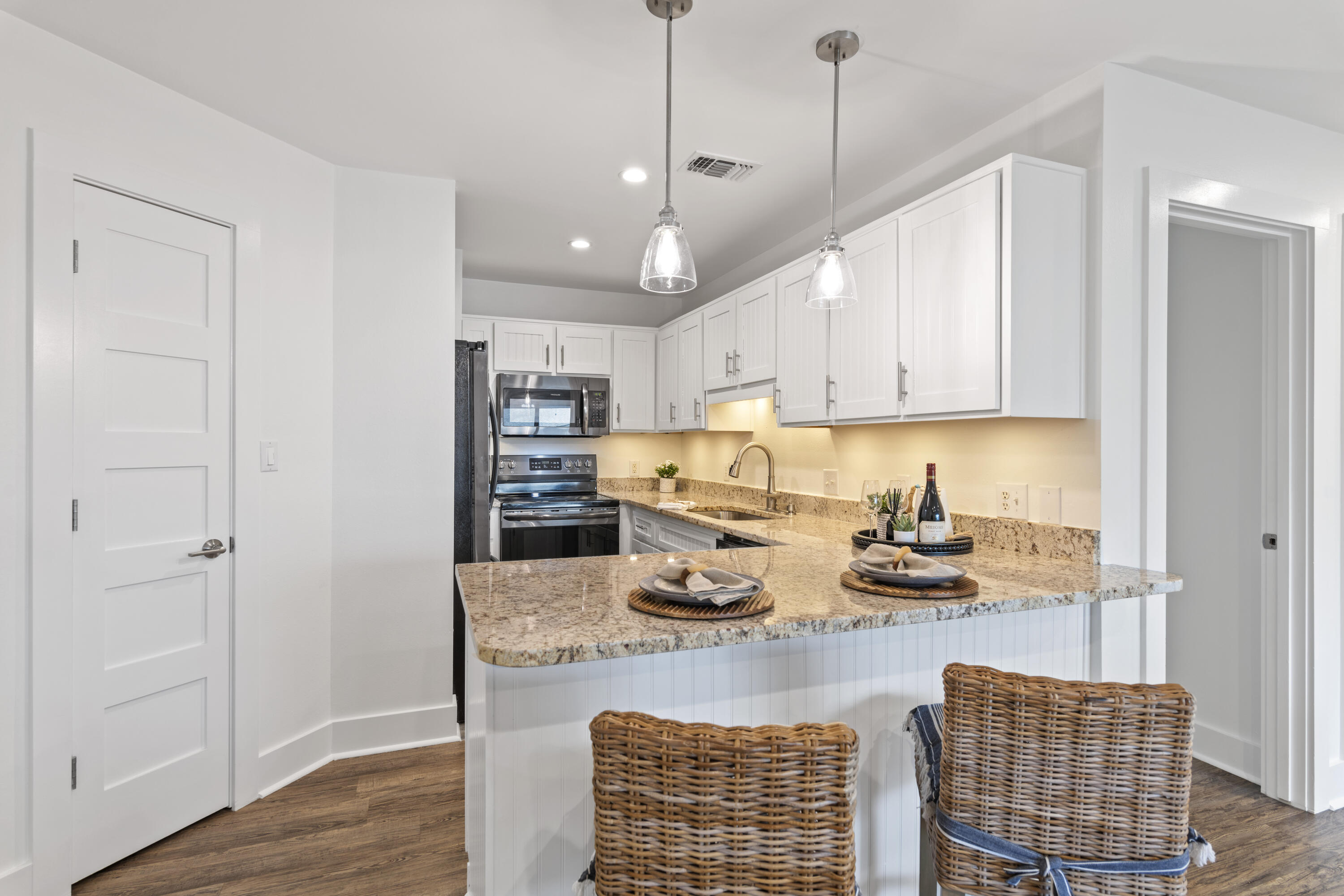 3799 East County Highway 30A, Unit F13 Santa Rosa Beach, FL 32459 - Photo 9 of 30 a kitchen with stainless steel appliances granite countertop a sink a stove and a wooden floors