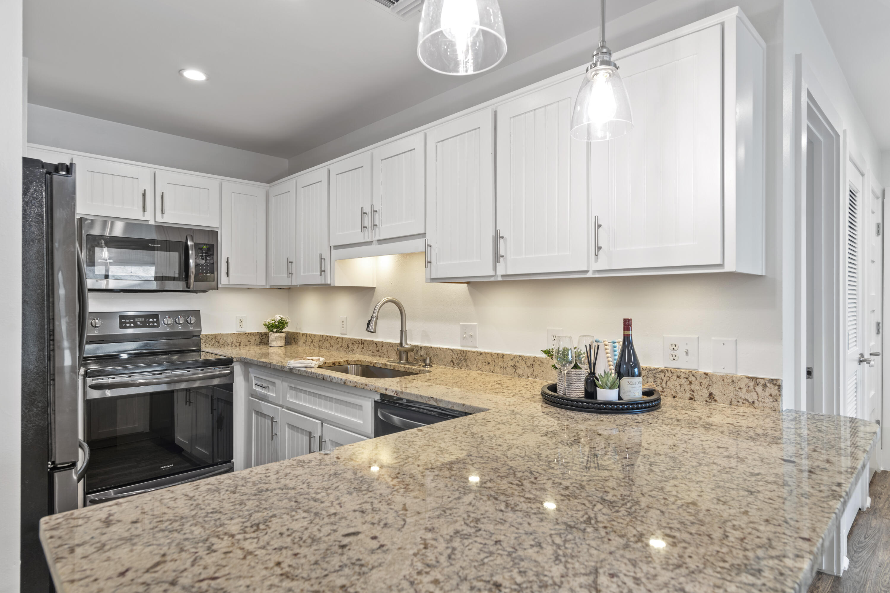 3799 East County Highway 30A, Unit F13 Santa Rosa Beach, FL 32459 - Photo 10 of 30 a kitchen with stainless steel appliances granite countertop a stove a sink and a white cabinets