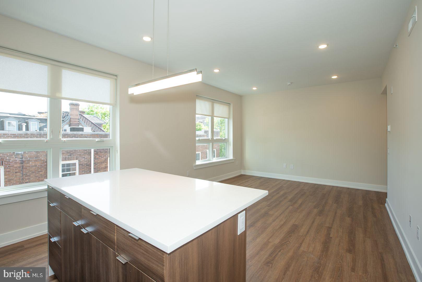 4534 Spruce Street, Unit 1BB4 Philadelphia, PA 19139 - Photo 2 of 9 a kitchen with a wooden floor and large window