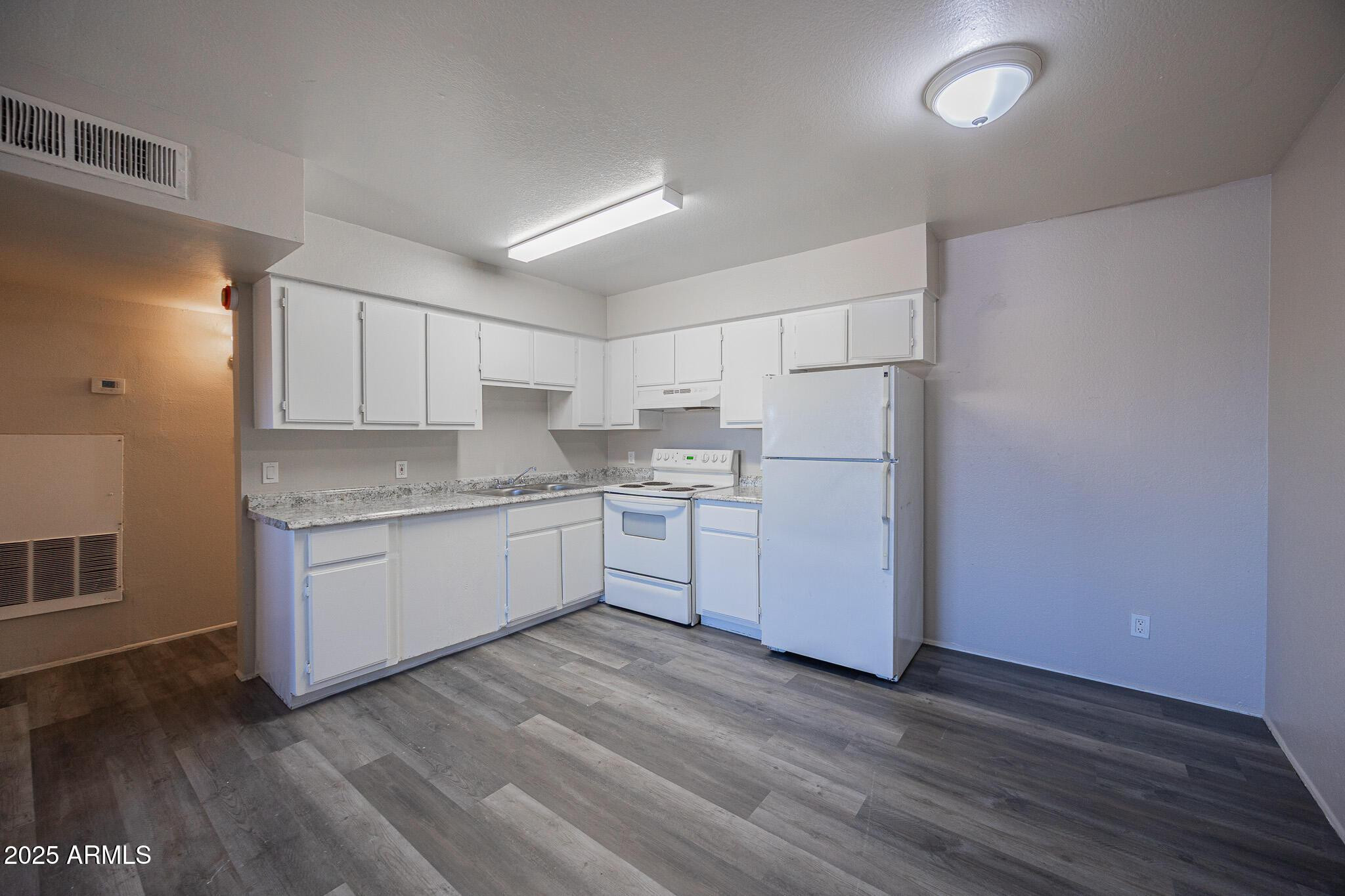 1703 West Mountain View Road, Unit 14 Phoenix, AZ 85021 - Photo 4 of 14 a kitchen with granite countertop white cabinets and white appliances