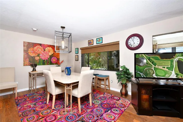 a view of a dining room with furniture a rug and a flat screen tv