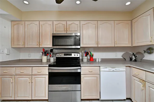 a kitchen with white cabinets and white appliances