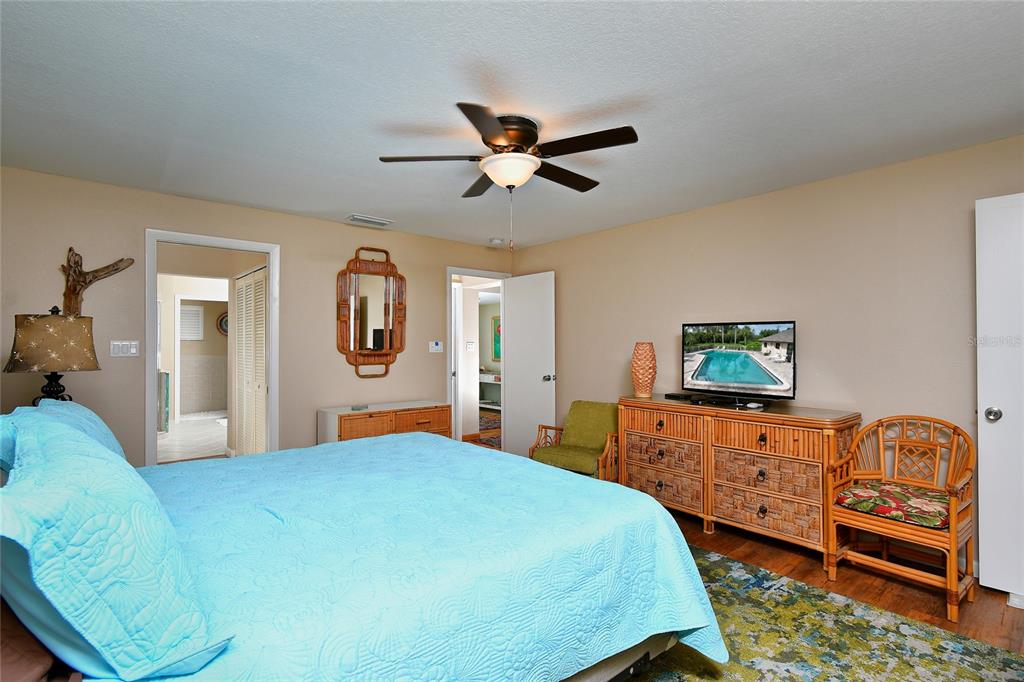 2 Pirates Lane, Unit 21C Punta Gorda, FL 33955 - Photo 19 of 36 a bedroom with a bed and wooden floor