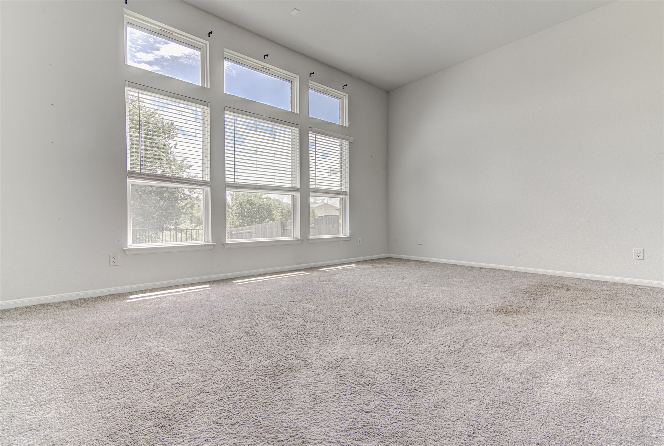 774 Cherrystone Loop Buda, TX 78610 - Photo 16 of 38 A spacious room offers soaring ceilings and ample daylight through large, well-placed windows.